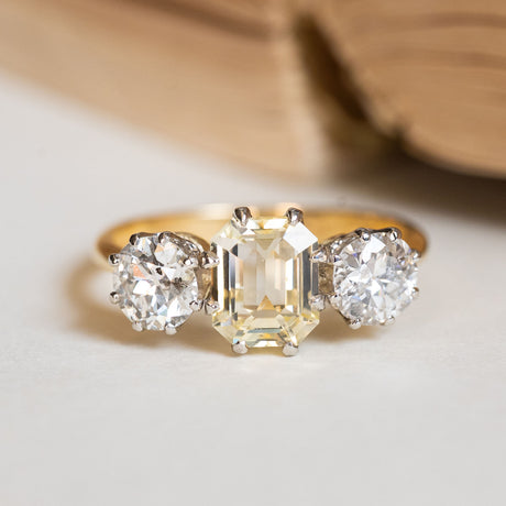 Vintage 1970s yellow sapphire and old-cut diamond three-stone ring featuring a yellow sapphire centre stone.