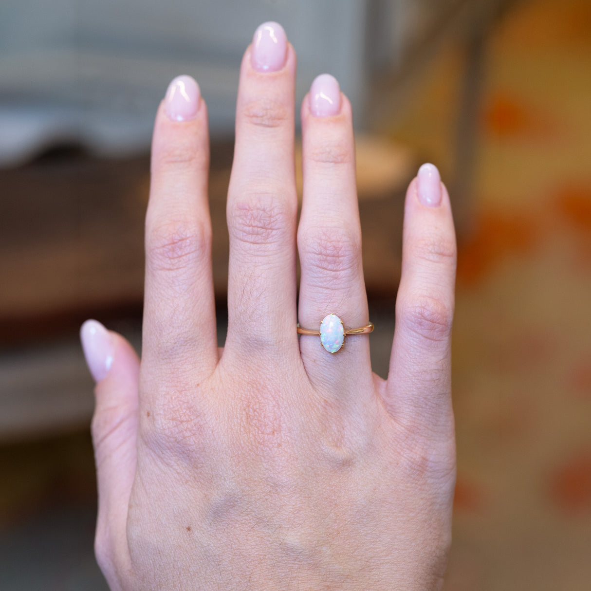Vintage 1990s precious opal solitaire ring worn on hand.