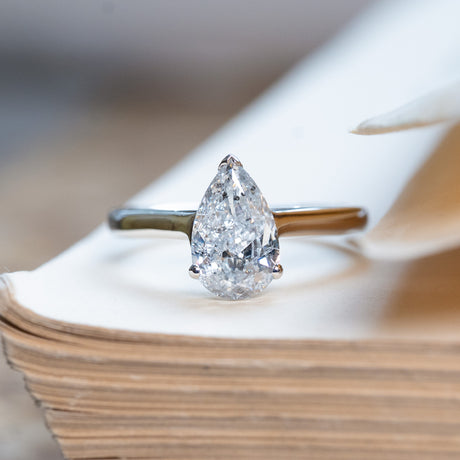 Vintage 1990s salt and pepper diamond solitaire ring with pear-shaped diamond on polished band.