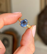 Vintage 1990s sapphire and diamond engagement ring with a blue sapphire centre and diamond accents, displayed while held by hand.