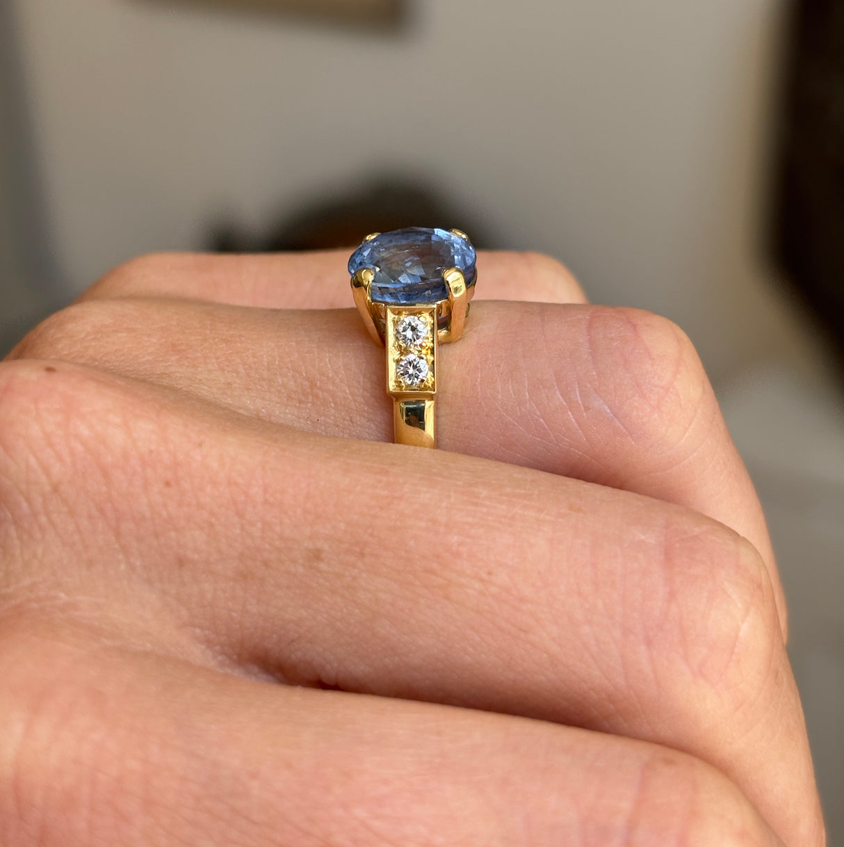 Vintage 1990s sapphire and diamond engagement ring showcasing a blue sapphire centre stone and diamond accents, displayed on a hand.