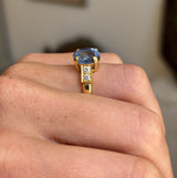 Vintage 1990s sapphire and diamond engagement ring showcasing a blue sapphire centre stone and diamond accents, displayed on a hand.