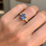 Vintage 1990s sapphire and diamond engagement ring with a blue sapphire centre and diamond detailing, worn on a hand.