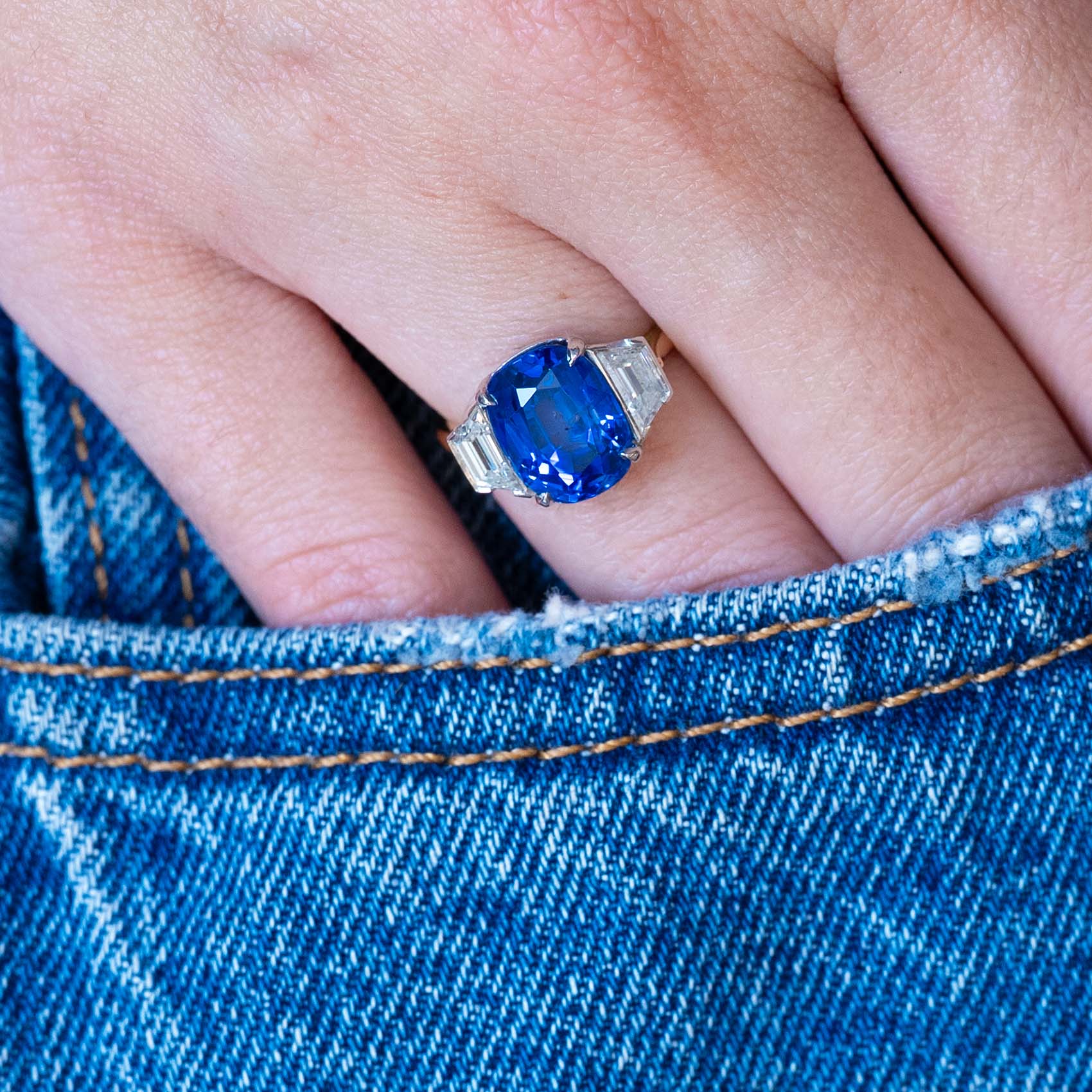 Vintage 1990s sapphire and diamond three-stone ring worn with hand resting in denim pocket.