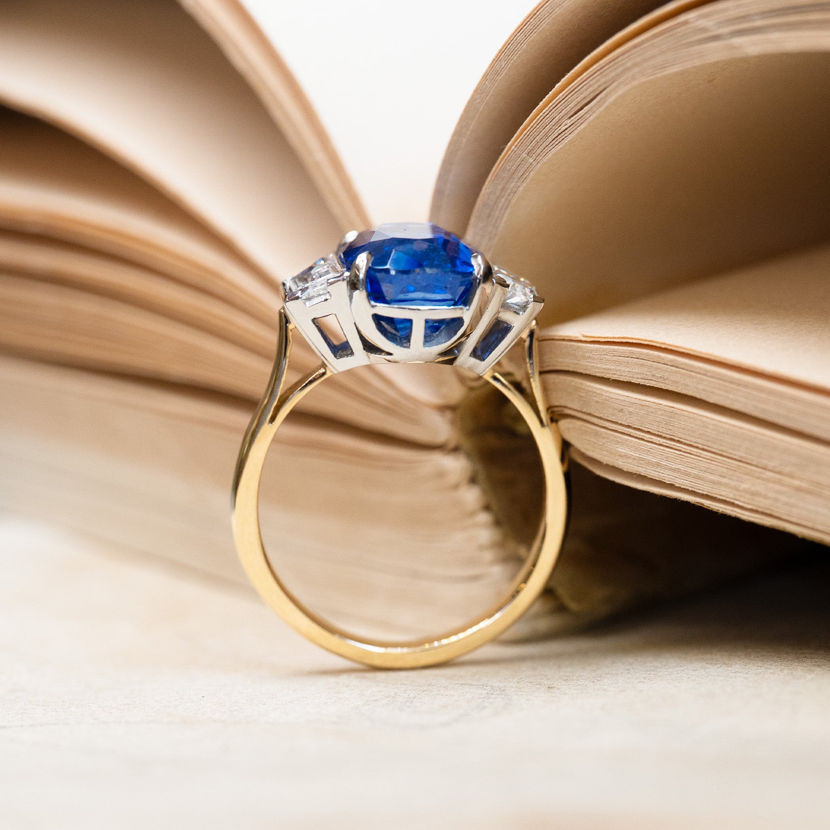 Vintage 1990s sapphire and diamond three-stone ring showing structured gallery and gold band detail.