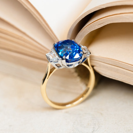 Vintage 1990s sapphire and diamond three-stone ring with elevated sapphire setting and diamond shoulders.