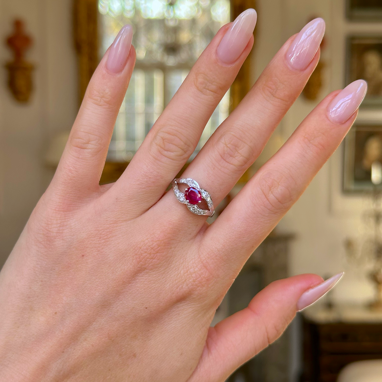 Vintage art deco ruby and diamond ring worn on hand. 