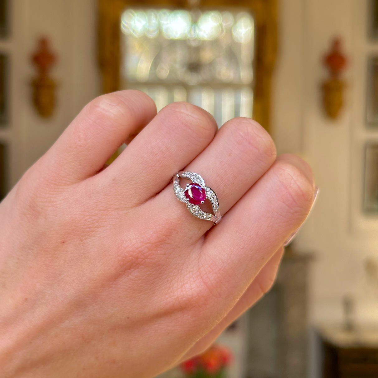 Vintage art deco ruby and diamond ring worn on closed hand. 