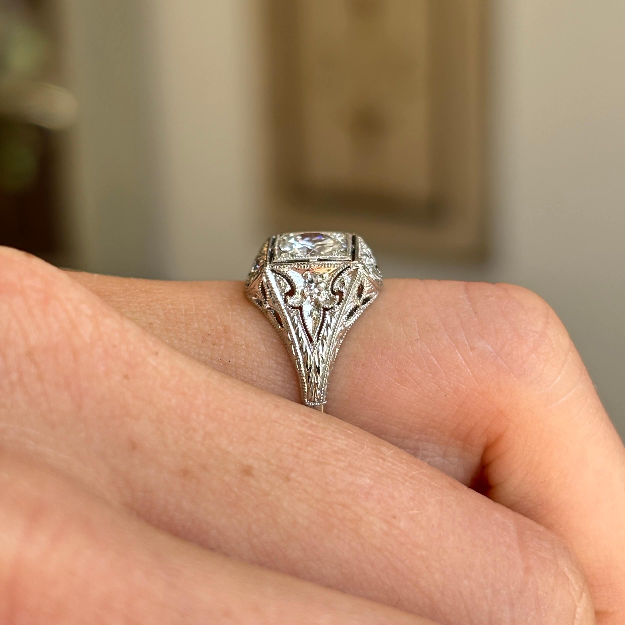 Vintage Art Deco diamond cluster ring featuring a floral-inspired diamond cluster on a hand with blurred background