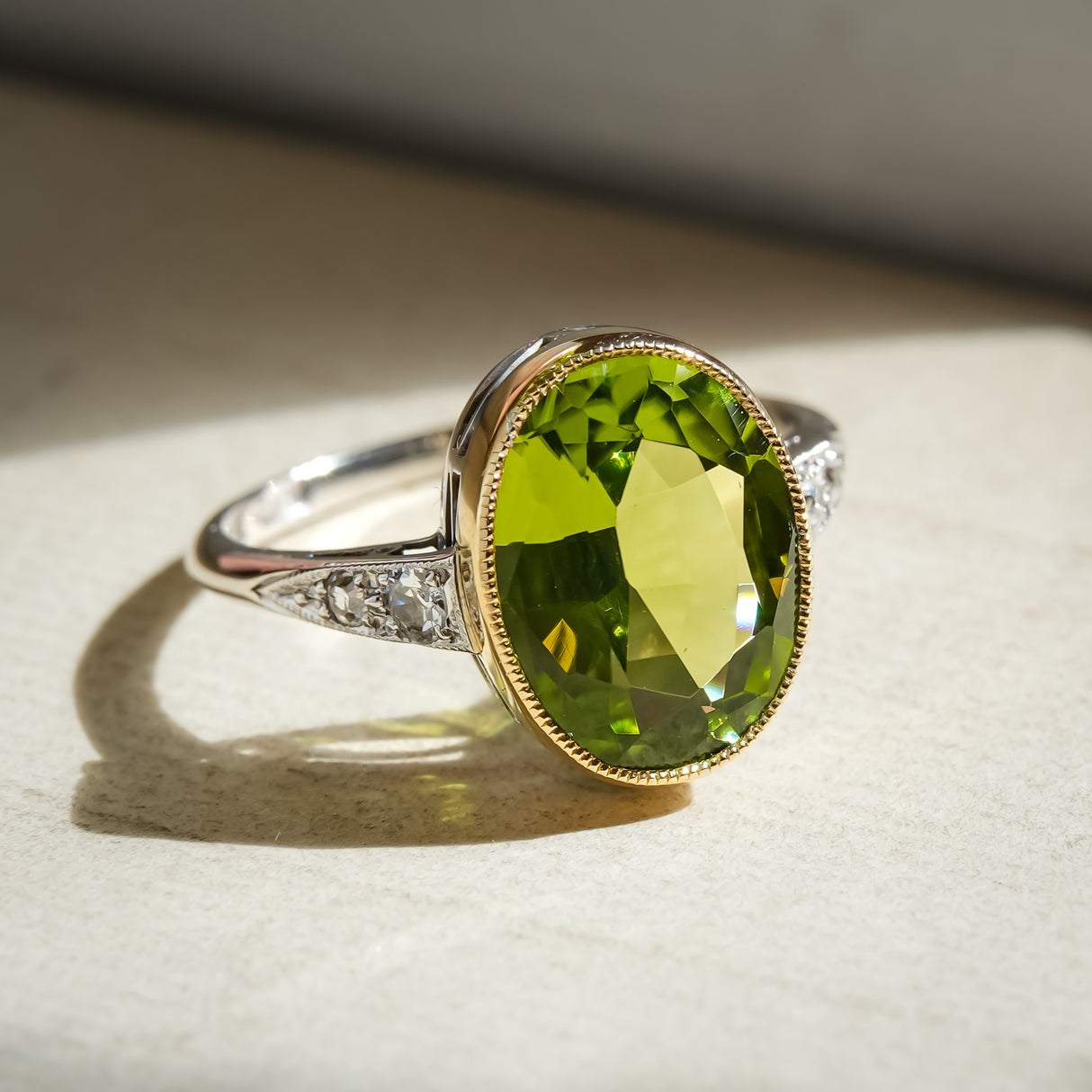 Vintage Art Deco peridot ring with oval green gemstone and diamond accents