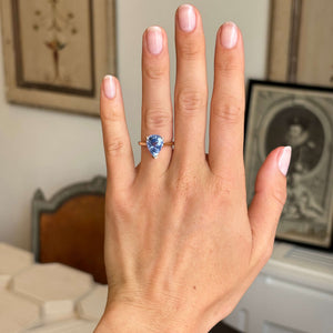 Vintage inspired pear-cut bluebell sapphire solitaire engagement ring worn on hand, showcasing a vibrant bluebell sapphire in a yellow gold solitaire setting.