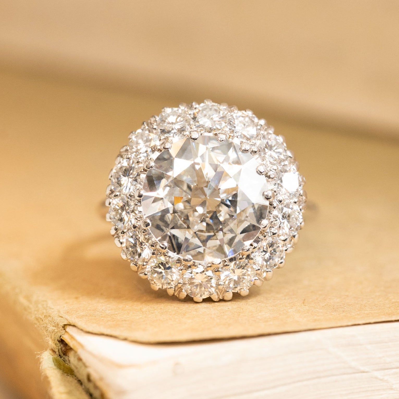 Vintage old-cut diamond cluster ring featuring a large central diamond surrounded by a halo of sparkling old-cut diamonds in white gold.