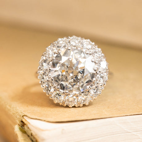 Vintage old-cut diamond cluster ring featuring a large central diamond surrounded by a halo of sparkling old-cut diamonds in white gold.