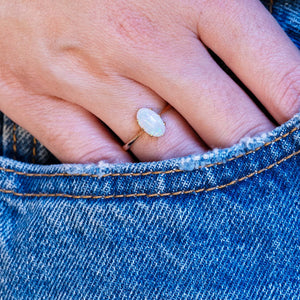 Vintage precious opal solitaire ring styled with denim pocket.