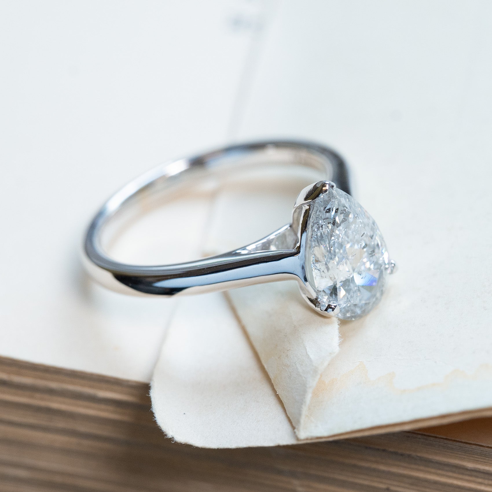Vintage 1990s salt and pepper diamond solitaire ring with elongated pear-shaped diamond and sleek band.