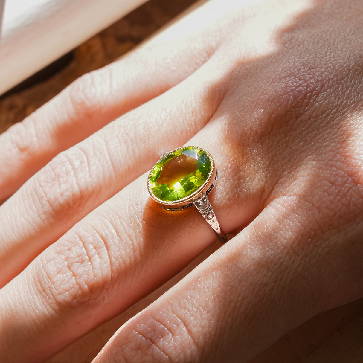 Vintage Art Deco peridot ring with oval green gemstone worn on hand