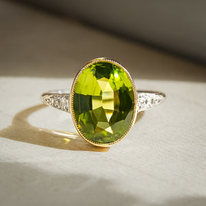 Vintage peridot ring with oval green gemstone and diamond halo setting