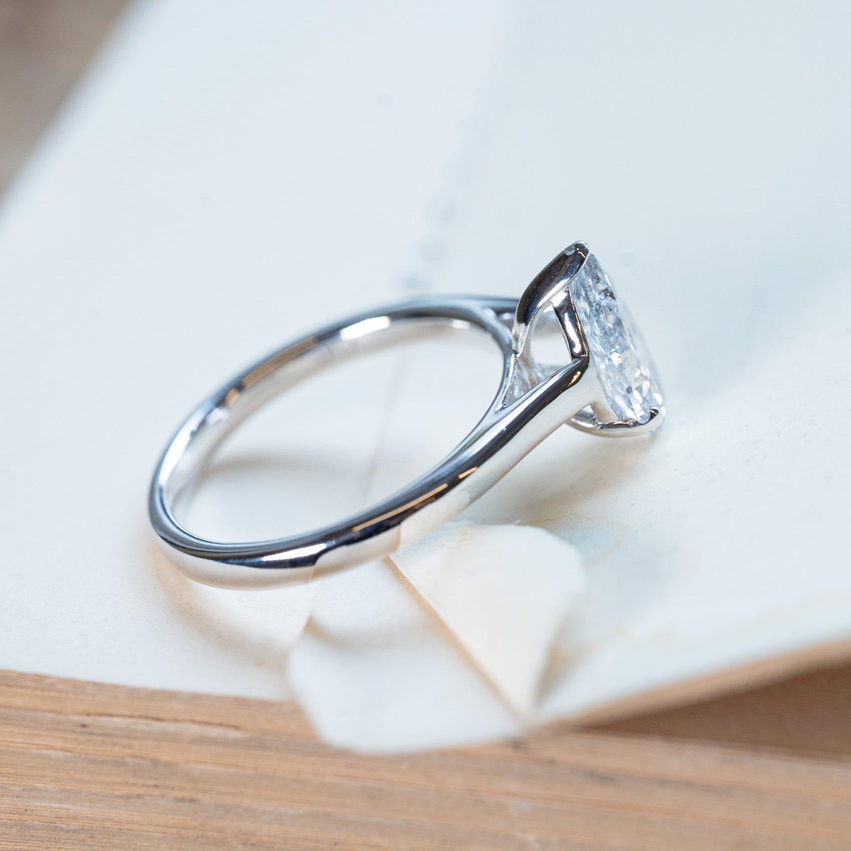 Vintage 1990s salt and pepper diamond solitaire ring with tapered polished band and pear-shaped diamond.
