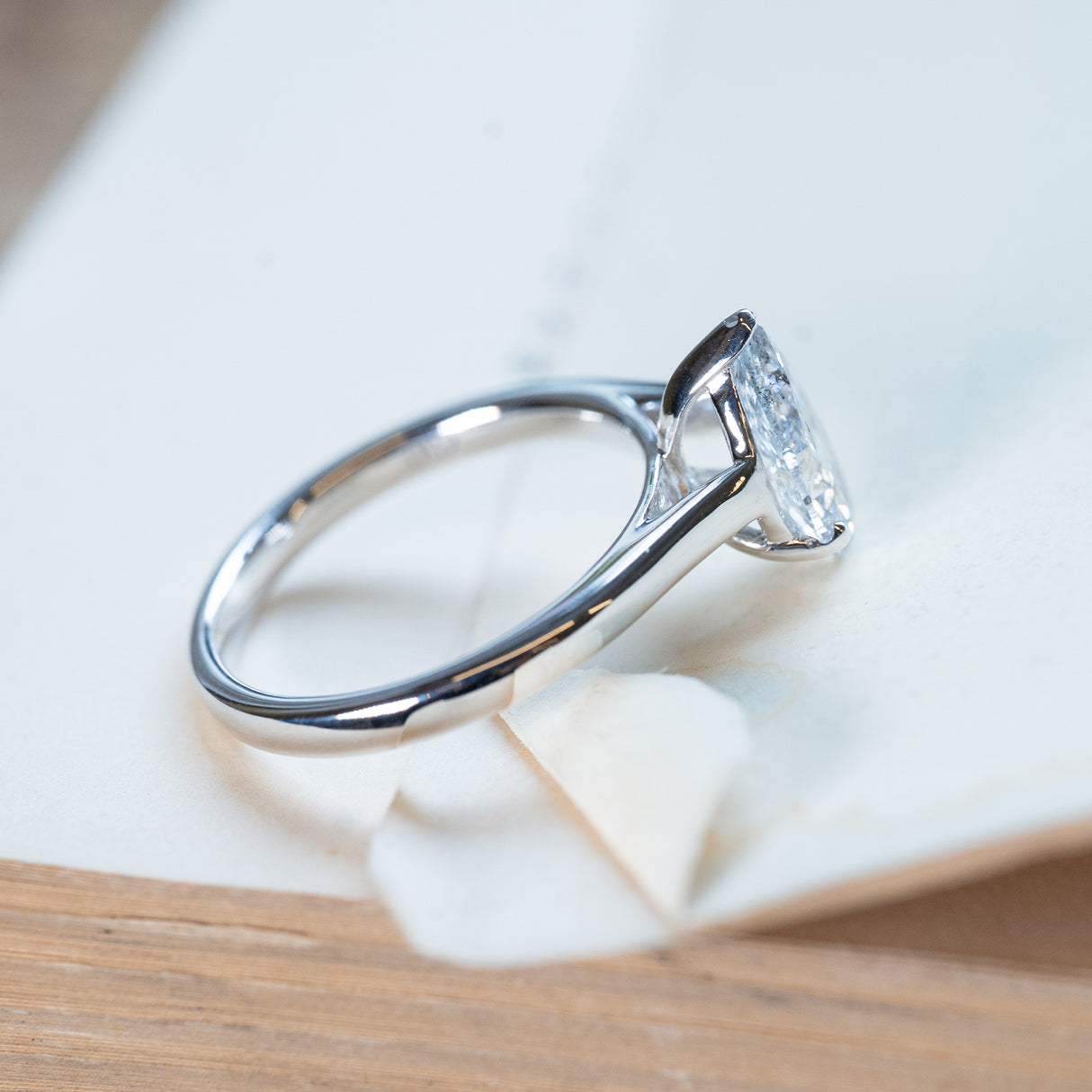 Vintage 1990s salt and pepper diamond solitaire ring with tapered polished band and pear-shaped diamond.