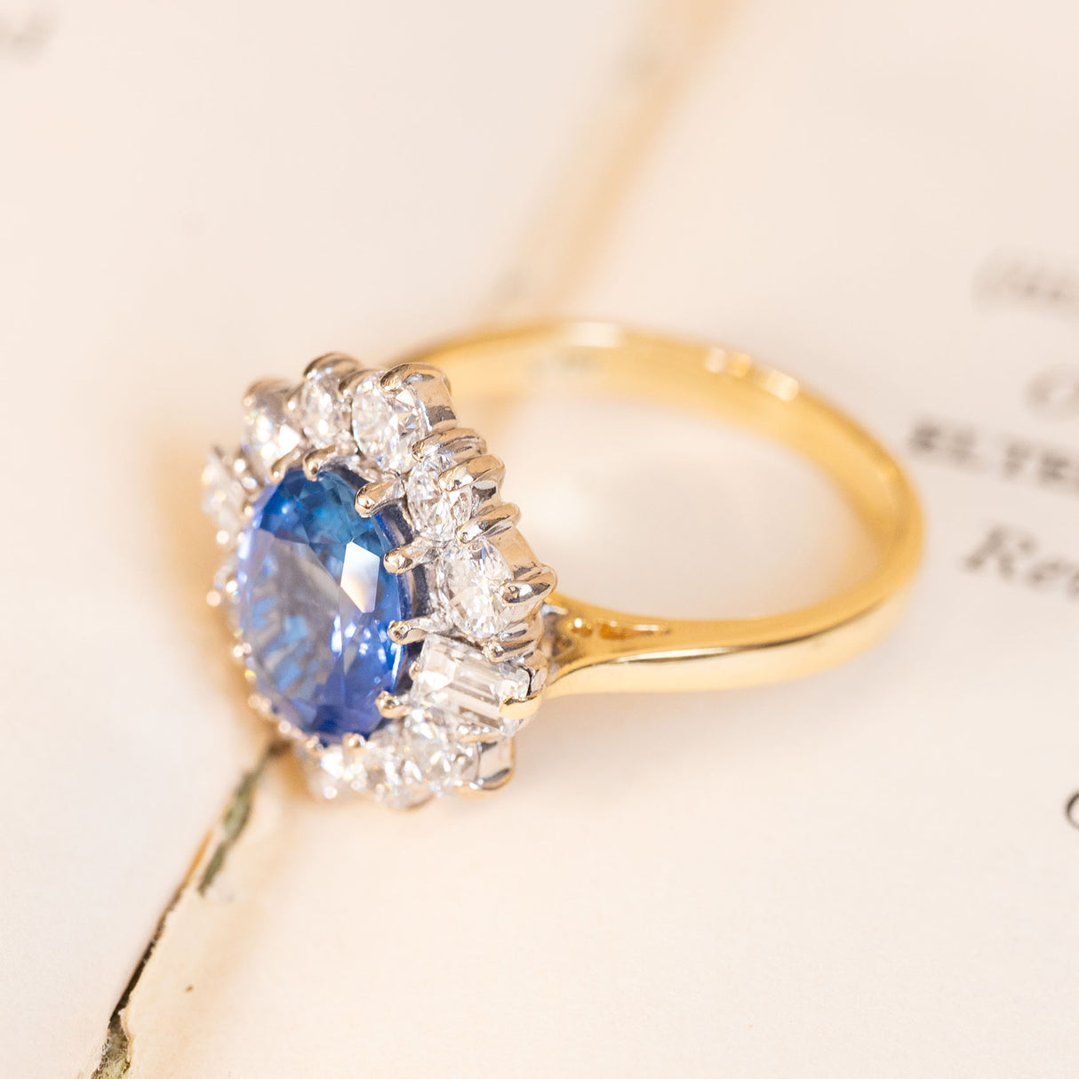 Vintage 1980s cornflower blue sapphire and diamond cluster ring in polished yellow gold.