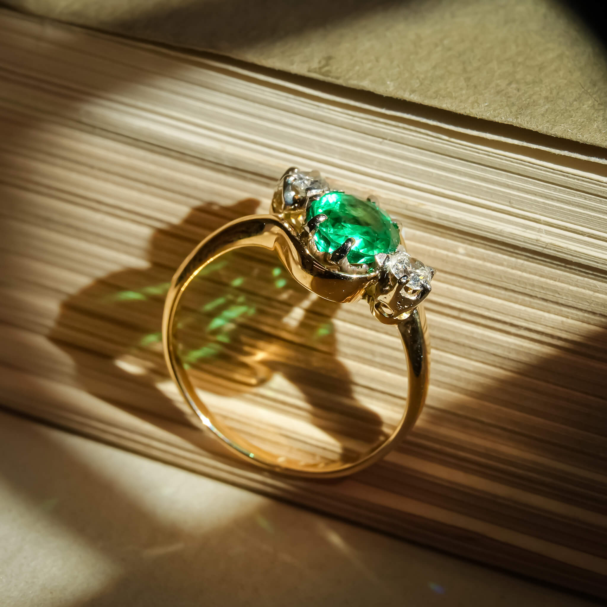 Emerald and diamond three stone ring with classic gold setting