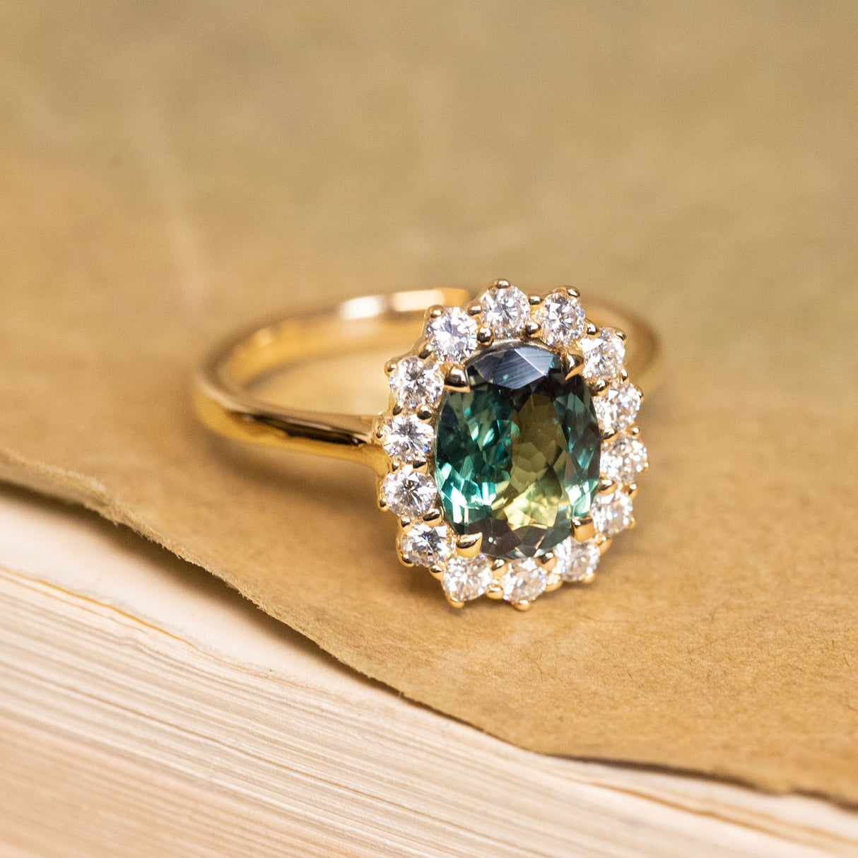 Green alexandrite cluster ring showcasing a colour-changing alexandrite framed by sparkling diamonds in a timeless yellow gold design.