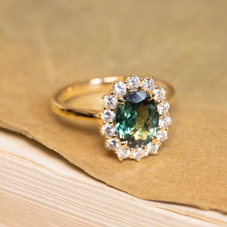Green alexandrite cluster ring showcasing a colour-changing alexandrite framed by sparkling diamonds in a timeless yellow gold design.