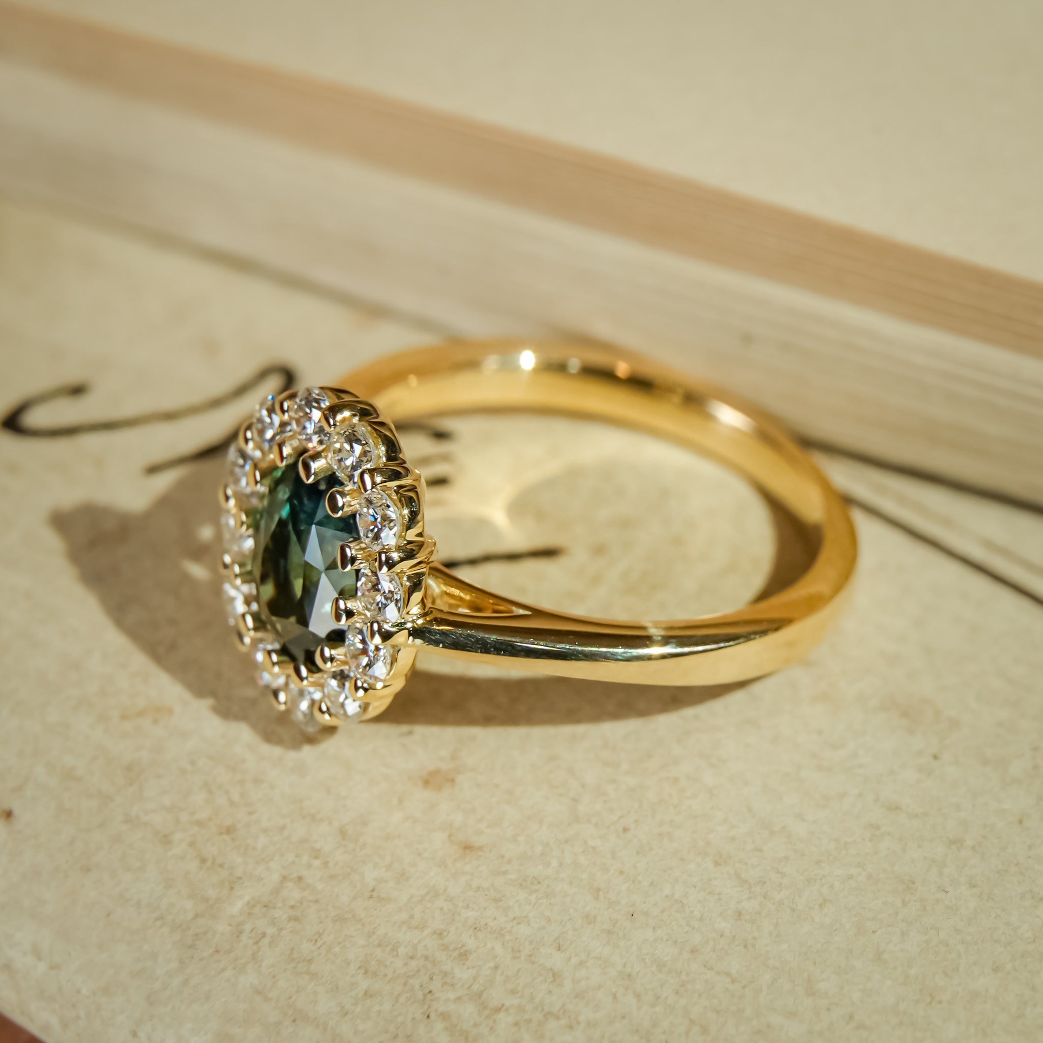 Vintage style green sapphire engagement ring with diamond cluster halo