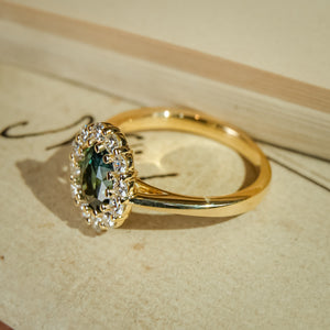 Vintage style green sapphire engagement ring with diamond cluster halo