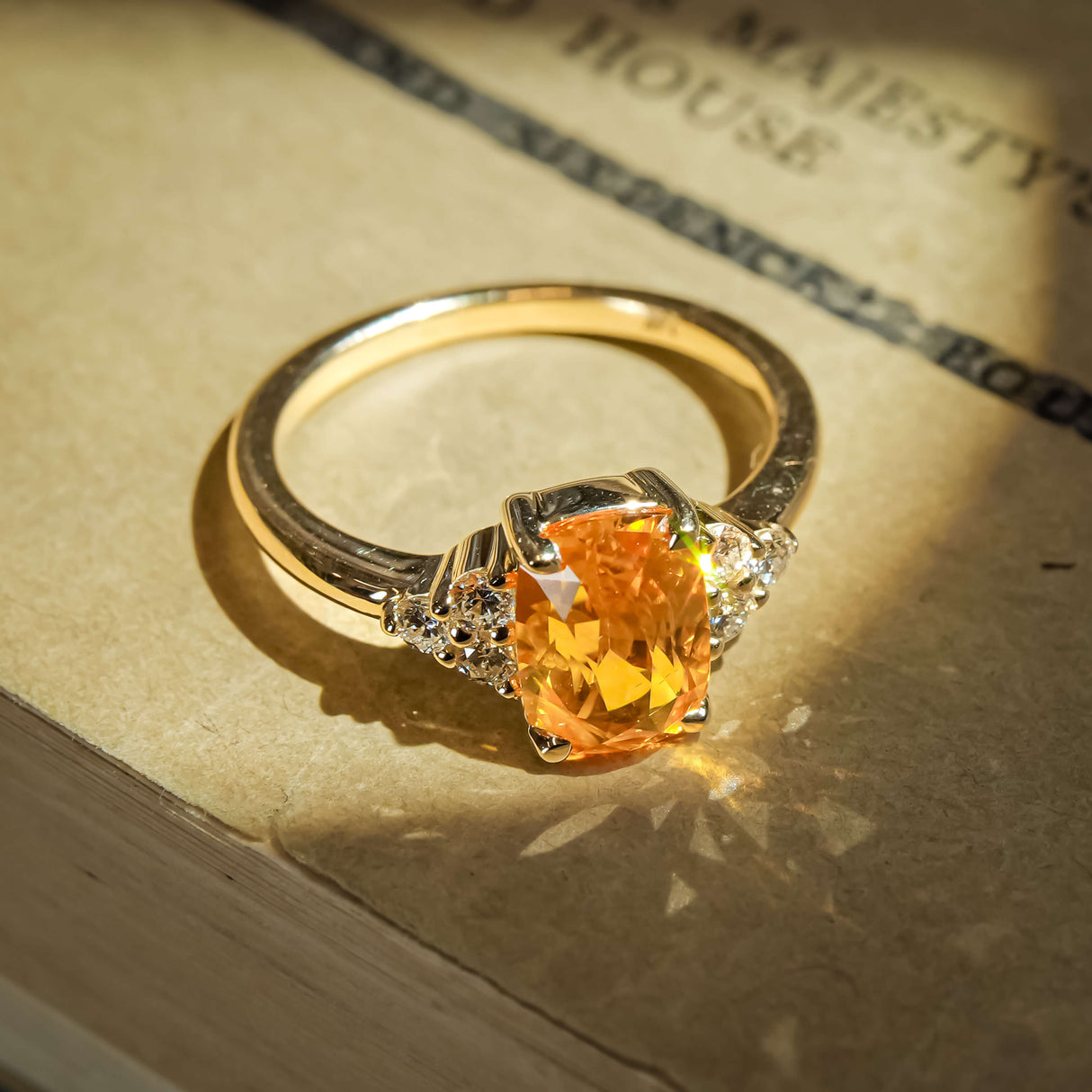 Orange cushion cut sapphire ring with diamond cluster trefoil design