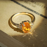 Orange cushion cut sapphire ring with diamond cluster trefoil design