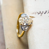 Vintage yellow oval diamond three-stone ring with bright half-moon diamonds and slim gold band.