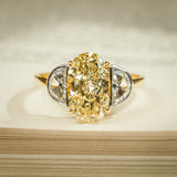 Yellow diamond three stone ring with oval center and half moon side stones