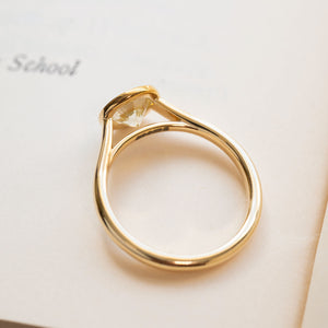 Diamond rub-over solitaire engagement ring in polished yellow gold with round brilliant-cut diamond.