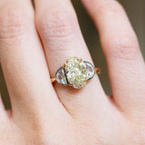 Vintage yellow oval diamond ring with half-moon side diamonds and polished gold setting.
