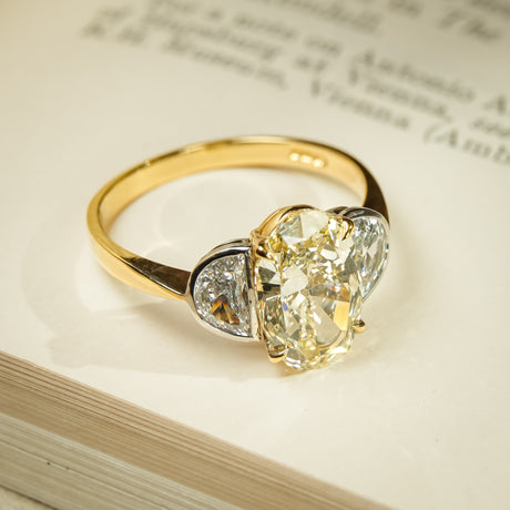 Yellow oval diamond three stone ring with half moon diamond side stones