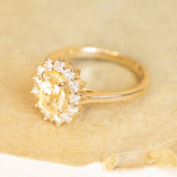 Yellow sapphire and diamond cluster engagement ring in polished yellow gold.