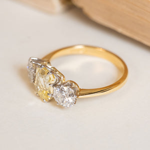 Vintage 1970s three-stone ring with an emerald-cut yellow sapphire flanked by old-cut diamonds in yellow and white gold.