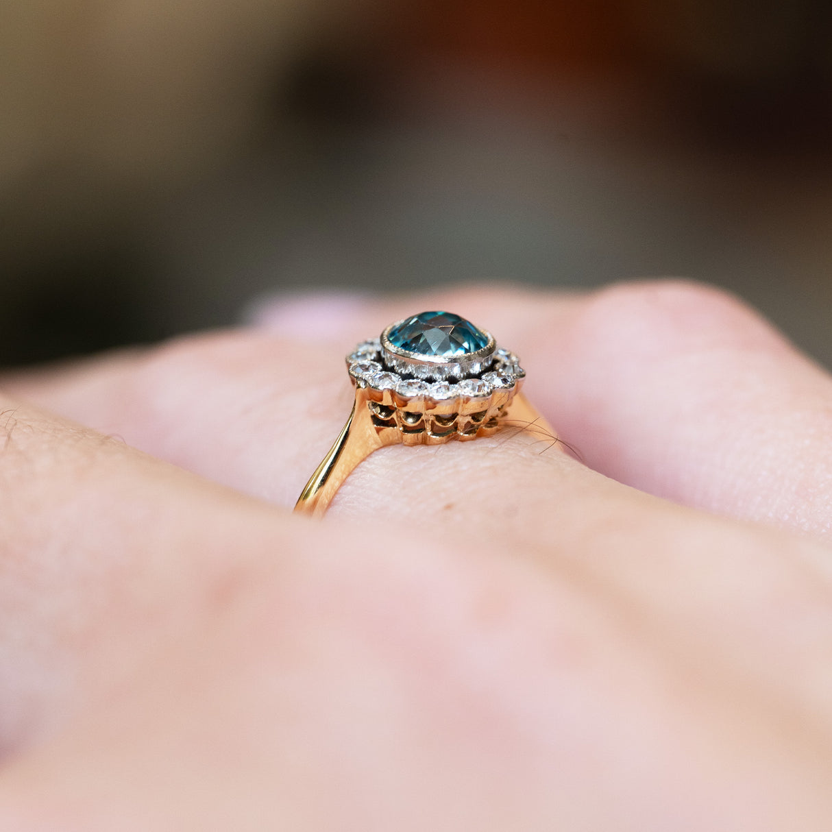 Antique zircon cluster ring detail highlighting raised setting and surrounding diamonds.
