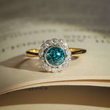 Antique 1920s zircon ring with round blue zircon and diamond cluster halo