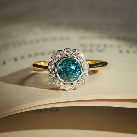Antique 1920s zircon ring with round blue zircon and diamond cluster halo