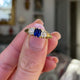 Sapphire and diamond three stone ring,held in fingers and rotated to give perspective.