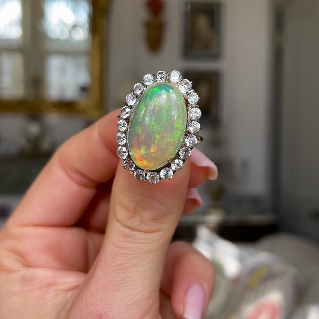 Antique opal and paste cluster ring, held in fingers and moved around to give perspective.