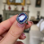 Early Victorian sapphire and diamond engagement ring, held in fingers and rotated to give perspective.