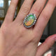 Antique opal and paste cluster ring, worn on hand and moved away from camera to give perspective.