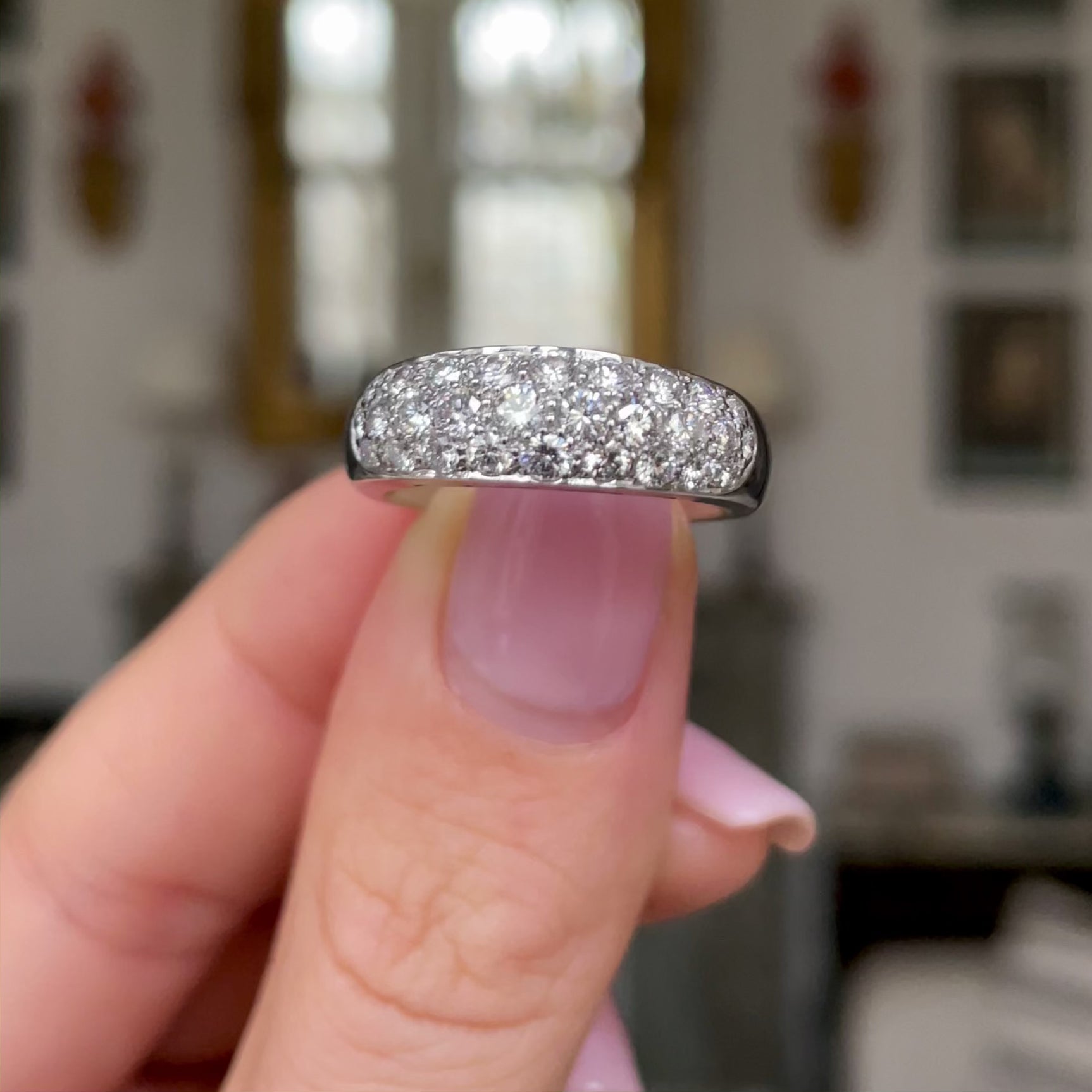 Diamond set platinum band held in fingers and moved around to give perspective.
