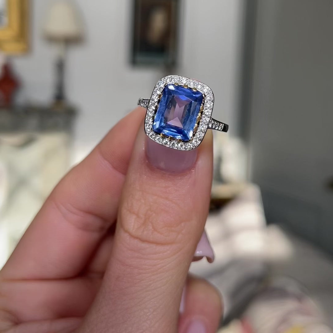 vintage sapphire and diamond cluster engagement ring held in fingers and moved around to give perspective. 