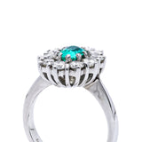 Austrian emerald and diamond cluster engagement ring, side view.