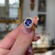 Victorian, sapphire and diamond cluster engagement ring, held in fingers and rotated to give perspective.