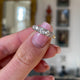 Victorian five stone diamond engagement ring, held in fingers and rotated to give perspective.